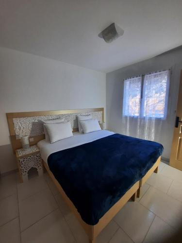 une chambre avec un grand lit avec une couverture bleue dans l'établissement Appartement indépendant, à Lorgues