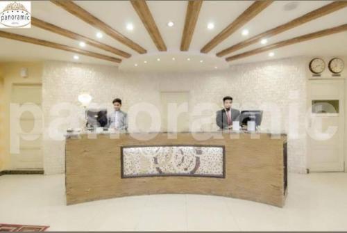 two men sitting at a counter in a office at Panoramic Hotel Lahore in Lahore