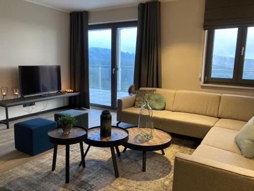 un soggiorno con un divano e due tavoli di Wellness Appartement Winterberg E2 a Winterberg