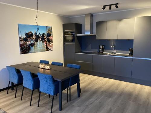 una cucina con tavolo da pranzo e sedie blu di Wellness Appartement Winterberg E2 a Winterberg
