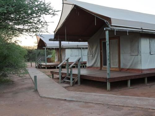 a building with a porch and a tent at Ngata Safari Lodge in Hammanskraal