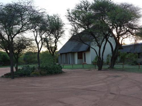 a white house with trees in front of it at Ngata Safari Lodge in Hammanskraal