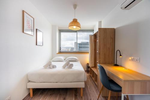 a small room with a bed and a desk and a desk at Le Prouvé II - Très bel appartement climatisé in Nancy