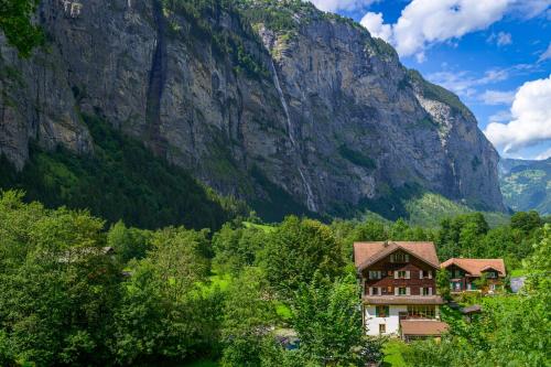 a building in front of a mountain at Alpenhof Mountain Lodge in Stechelberg