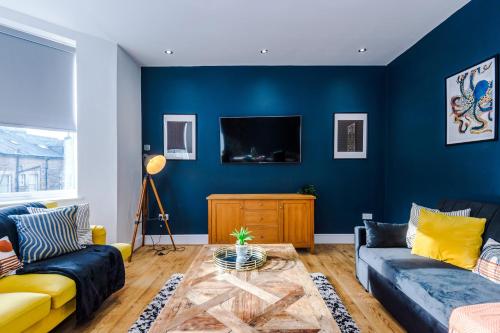 a blue living room with a couch and a table at The Harrogate Hub - 6 Bedrooms & Pool Table in Harrogate
