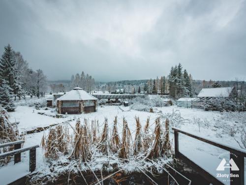 a garden covered in snow with a gazebo at Złoty Sen Agroturystyka in Stronie Śląskie