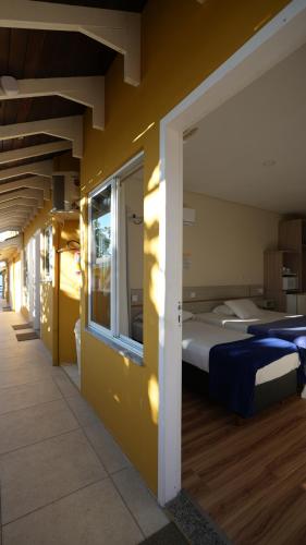 a bedroom with a large bed and a window at Pousada Areia Cristal in Bombinhas