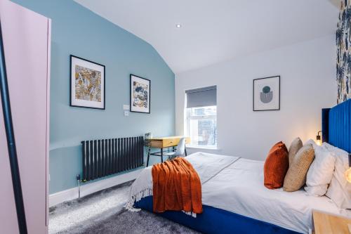 a bedroom with blue walls and a bed and a window at The Harrogate Hub - 6 Bedrooms & Pool Table in Harrogate