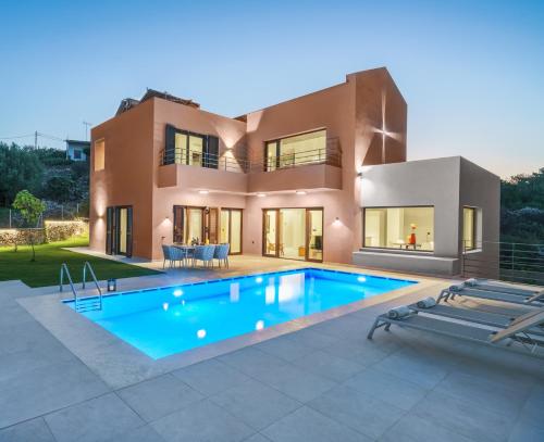 a villa with a swimming pool in front of a house at Olimpia Villas I Luxury villas with private pools! in Epáno Kefalás