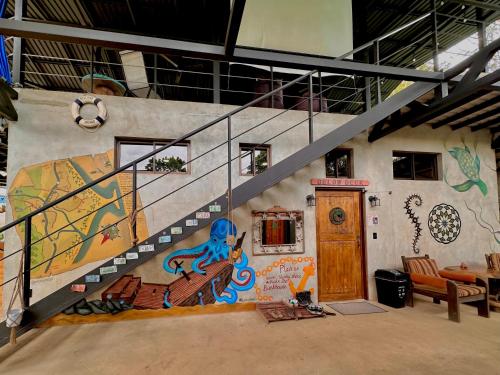 a staircase with a painting on the side of a building at Shipwrecked Hostel in Uvita
