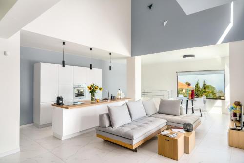 a living room with a couch and a kitchen at Olimpia Villas I Luxury villas with private pools! in Epáno Kefalás