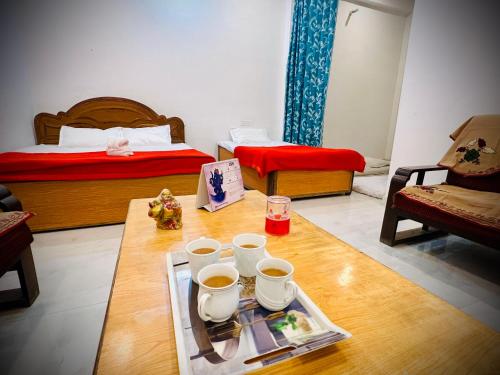 a room with two beds and a table with a tray of food at Vivanta Home Stay in Ayodhya