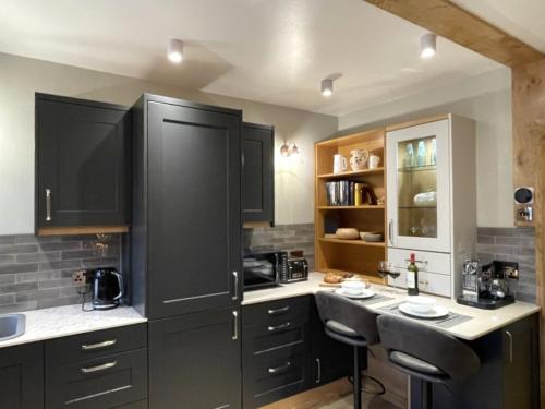 a kitchen with black cabinets and a counter top at Weavers Rest - New Boutique Retreat in Central Skipton with Parking in Skipton