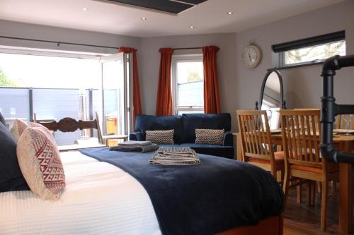 a bedroom with a bed and a table and chairs at Stylish Escape With Wood-Fired Hot Tub in Norwich