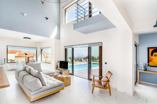 a living room with a couch and a tv at Olimpia Villas I Luxury villas with private pools! in Epáno Kefalás