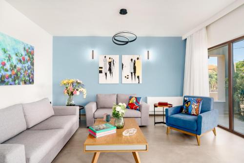 a living room with a couch and a table at Olimpia Villas I Luxury villas with private pools! in Epáno Kefalás