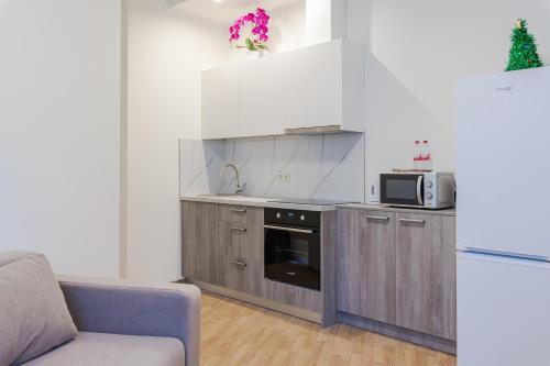 a kitchen with a couch and a microwave at Marmor House in Rīga