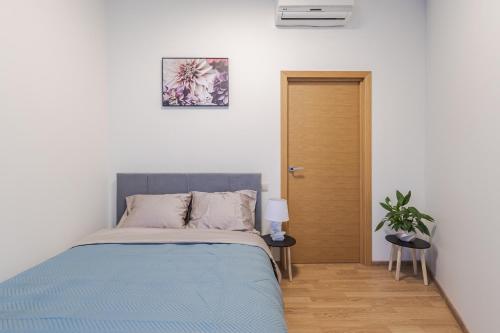 a bedroom with a bed with a blue blanket at Marmor House in Rīga