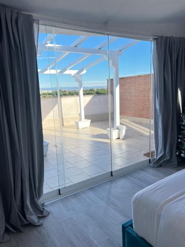 a bedroom with a view of the beach through glass at Mezzo Experience Holiday Home Eur in Rome
