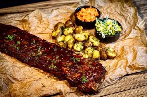 a piece of meat with potatoes and vegetables on a table at Hotel i Restauracja Czarny Kos in Borkowo