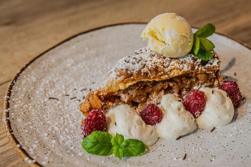 a dessert with ice cream and berries on a plate at Hotel i Restauracja Czarny Kos in Borkowo