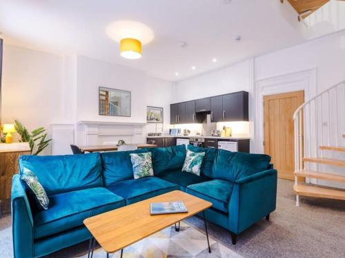 a living room with a blue couch and a table at Modern 2-Bed Apartment in City Centre in Hull