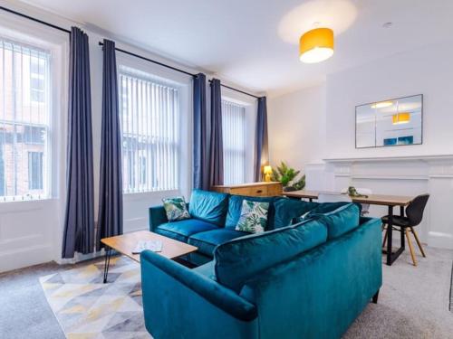 a living room with a blue couch and a table at Modern 2-Bed Apartment in City Centre in Hull