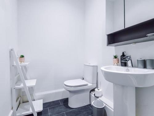 a bathroom with a white toilet and a sink at Modern 2-Bed Apartment in City Centre in Hull