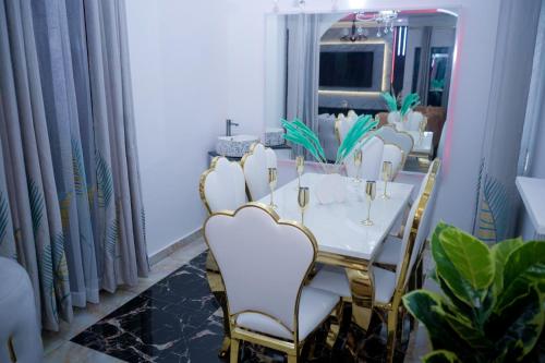 a dining room with a white table and chairs at Prince Home in Douala