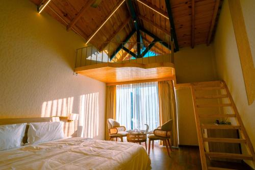 - une chambre avec une mezzanine et un bureau dans l'établissement The Barns Resort, à Bhimtal
