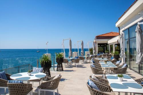a restaurant with tables and chairs overlooking the ocean at Park Plaza Histria Pula in Pula