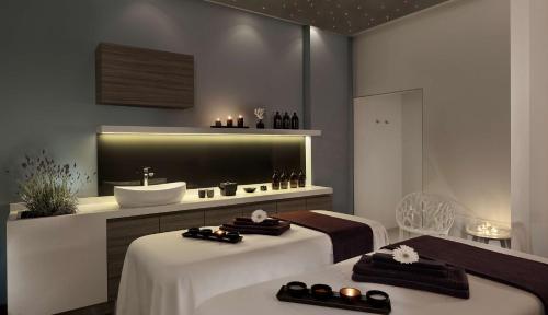 a bathroom with two beds and a sink at Park Plaza Arena Pula in Pula