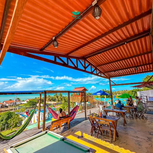 a deck with chairs and a pool table and a pool table at Pousada Bugaendrus in Touros