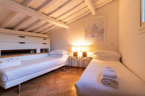 two beds in a room with wooden ceilings at Terrazza Minerva in Rome