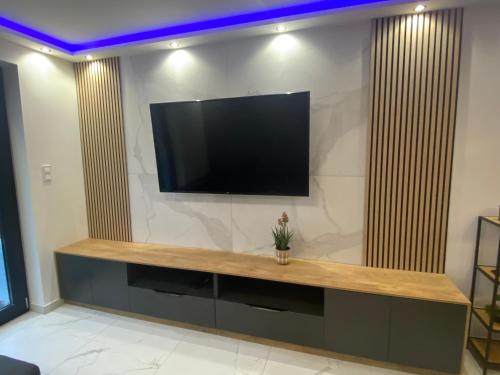 ein großes Unterhaltungszentrum mit einem TV an der Wand in der Unterkunft Waikiki Apartman House with Jacuzzi in Siófok