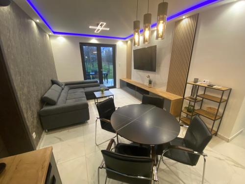 ein Wohnzimmer mit Tisch und Couch in der Unterkunft Waikiki Apartman House with Jacuzzi in Siófok