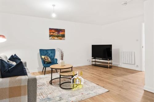 a living room with a couch and a table and a tv at Lochy Stay - SJA Stays - Modern 2 Bed Apartment in Aberdeen