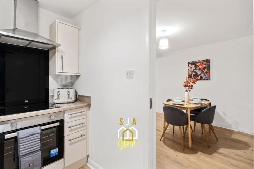 a kitchen with a table with chairs and a microwave at Lochy Stay - SJA Stays - Modern 2 Bed Apartment in Aberdeen