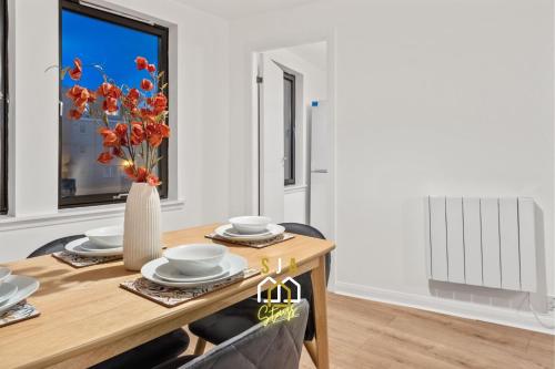 a dining room with a table and a vase with flowers at Lochy Stay - SJA Stays - Modern 2 Bed Apartment in Aberdeen