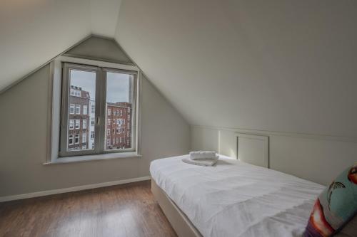 a white room with a bed and a window at Boutique Hotel Maldegem in Vlissingen