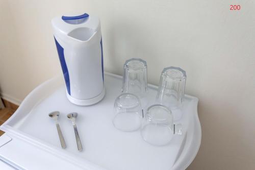 a white sink with a vase and three glasses on it at ATHENS COMMERCIAL in Athens