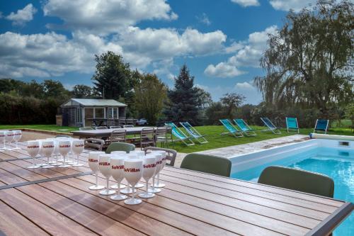 - une table en bois avec des verres à vin sur une terrasse à côté de la piscine dans l'établissement Crazy Villa Le Tertre 28 - Heated pool - Basket - 2h Paris - 44p, à Courtalain