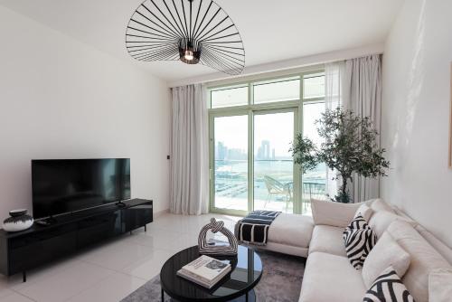 a white living room with a couch and a tv at Sunrise Bay, Emaar Beachfront Dubai Harbour - Mint Stay in Dubai