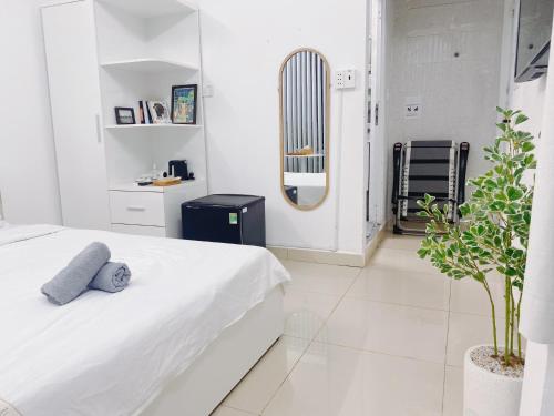 a white bedroom with a bed and a radiator at SAIGONESE Studio in Ho Chi Minh City