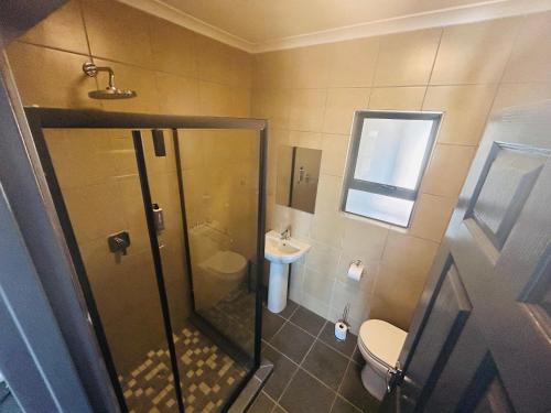 a bathroom with a shower and a toilet and a sink at Chill Out in Malelane
