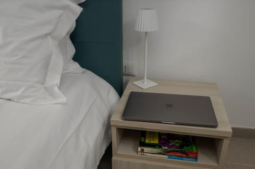 a laptop on a night stand next to a bed at Tenuta La Radicale - ZENO 61 intera villa in Subiaco