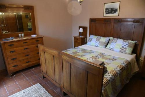a bedroom with a wooden bed and a dresser at Il borgo come in un castello in Montabone