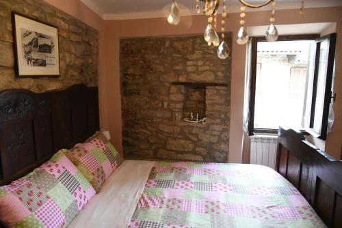 a bedroom with a bed and a stone wall at Il borgo come in un castello in Montabone