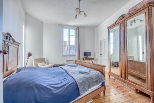une chambre avec un lit et un grand miroir dans l'établissement maison de famille, à Mortagne-sur-Gironde