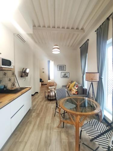 a living room with a table and a kitchen at Apartamentos La Higuera by VGH in Jerez de la Frontera